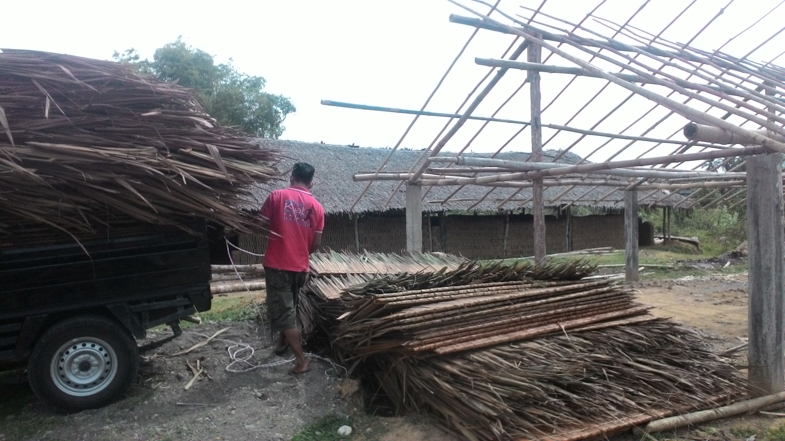 Seorang Pekerja Sedang Menurunkan Anyaman Daun Rumbia Di Tempat Produksi Batu Bata
